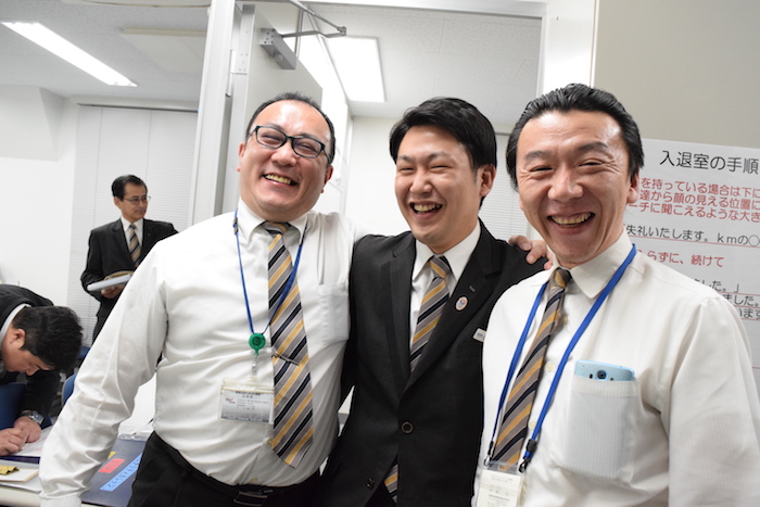 国際自動車（kmタクシー）の人財研修課の同僚二人と、肩を組んで満面の笑みを浮かべている小野さんの写真