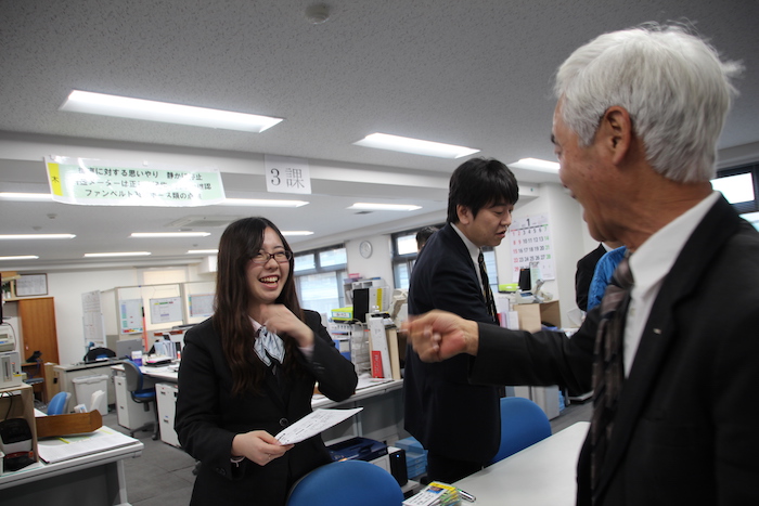同僚と笑顔で話をする田島さんの写真