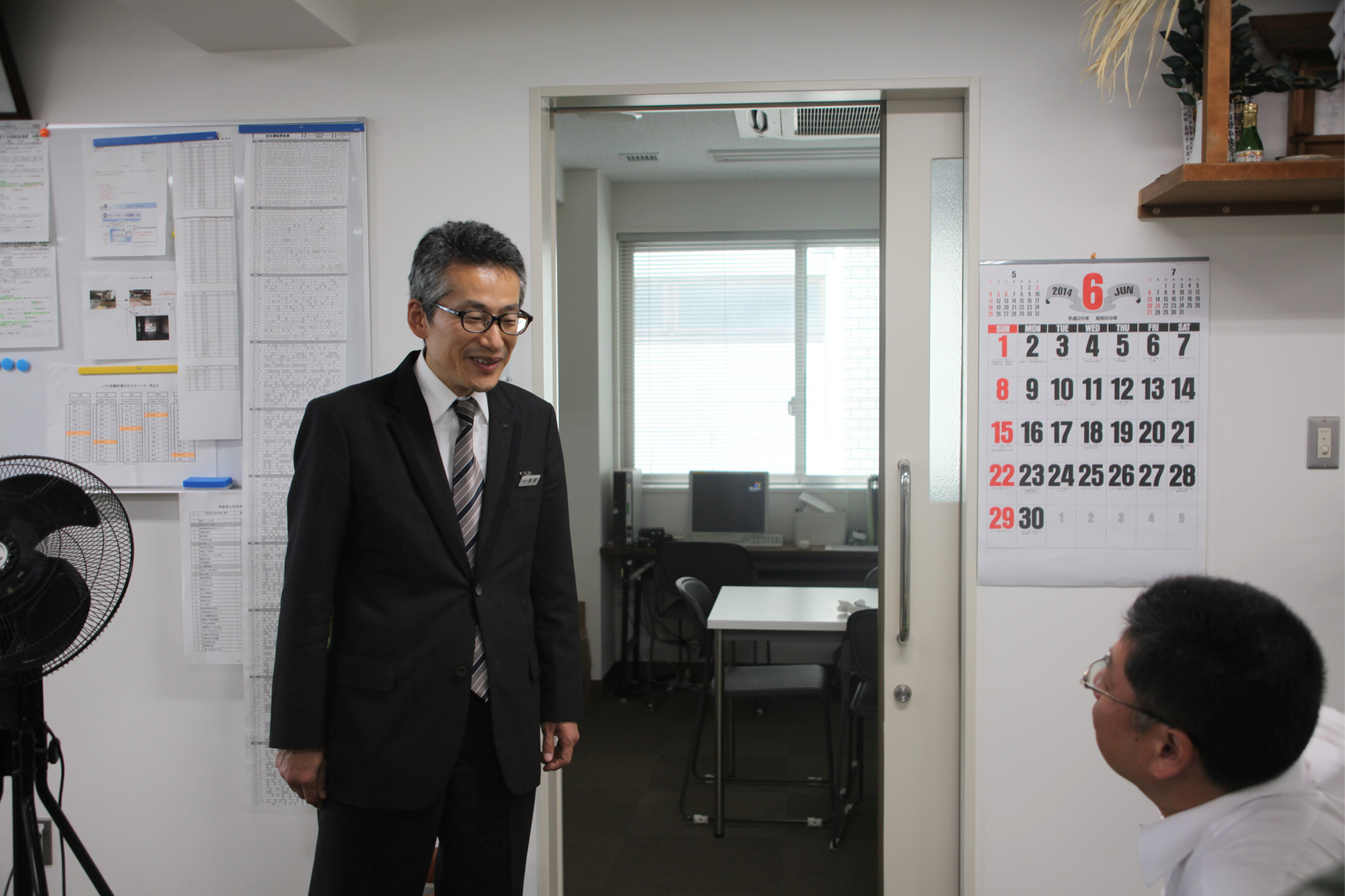 同僚と話をしている、50代で転職した国際自動車(㎞タクシー)のタクシードライバー栗原さんの写真