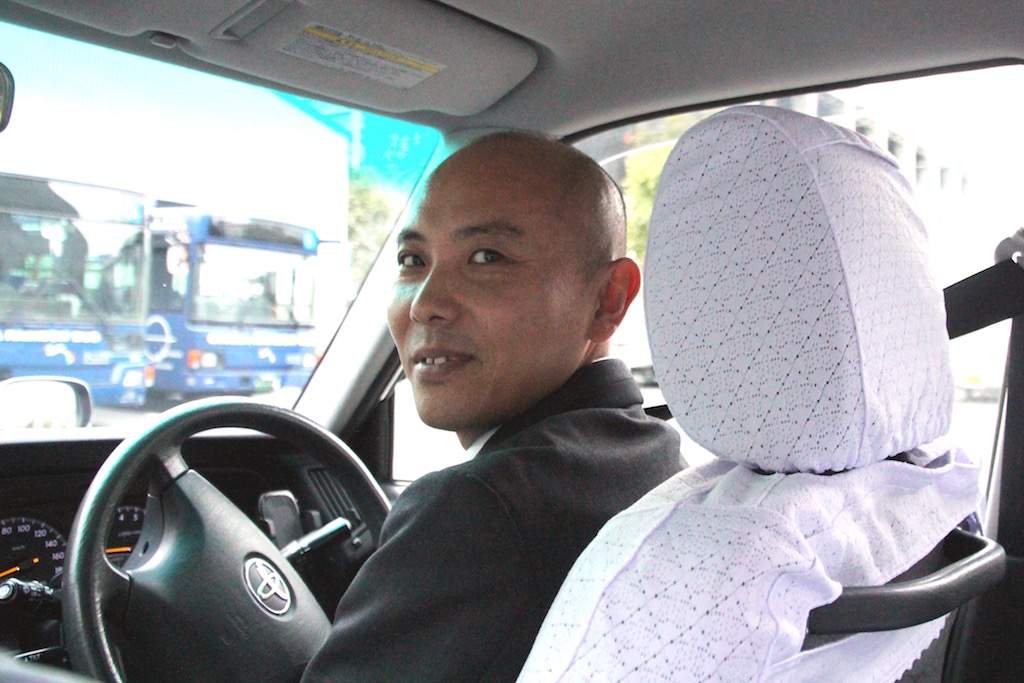 接客業から国際自動車（kmタクシー）に転職したタクシードライバーとして働く大河原さんのインタビュー中の笑顔