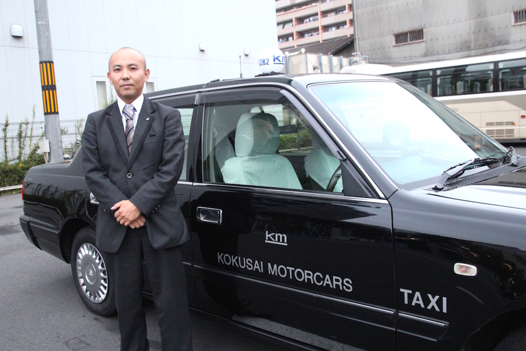 接客業から国際自動車（kmタクシー）に転職したタクシードライバーとして働く大河原さんのインタビュー中の笑顔